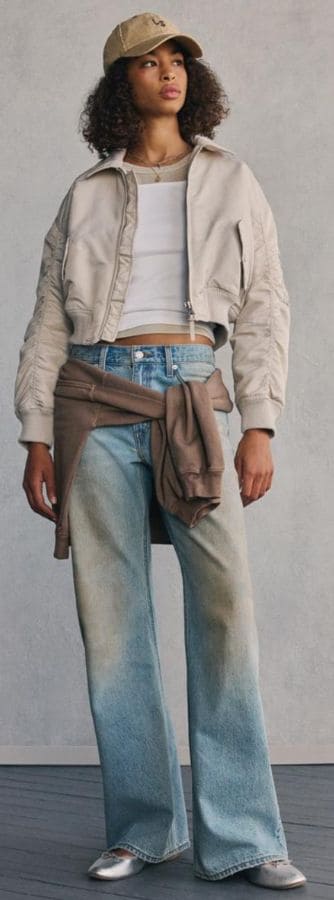 Damska stylizacja premium z jasną bomberką i jeansami jako nowoczesna odzież wizerunkowa dla firm i zespołów